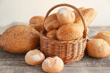 Beautiful composition with wicker basket and delicious bread on wooden table