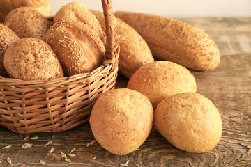 Beautiful composition with wicker basket and delicious bread on wooden table