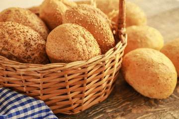 Beautiful composition with wicker basket and delicious bread on wooden table