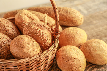 Beautiful composition with wicker basket and delicious bread on wooden table