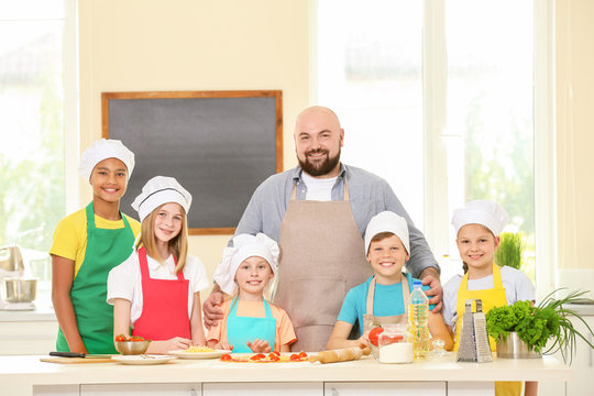 Group of children and teacher in kitchen during cooking classes