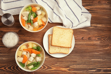 Composition with delicious turkey soup in two bowls on wooden table