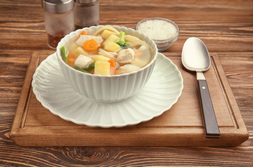 Bowl with delicious turkey soup on wooden table