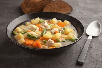 Plate with delicious turkey soup on table