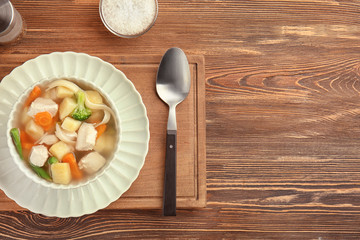 Bowl with delicious turkey soup on wooden table