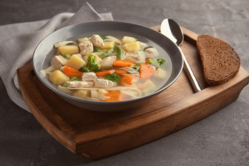 Plate with delicious turkey soup on table