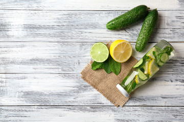 Composition with bottle of infused water on wooden background