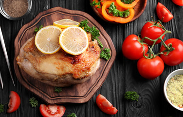 Cutting board with delicious roasted turkey fillet and lemon on wooden table