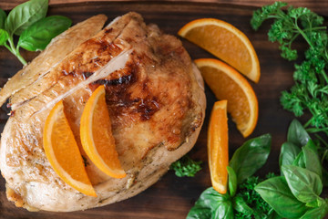 Cutting board with delicious roasted turkey and orange, closeup