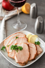 Plate with delicious sliced turkey fillet on table