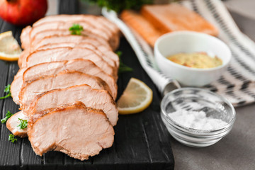 Cutting board with delicious sliced turkey fillet on table