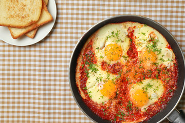 Frying pan with eggs in purgatory on napkin