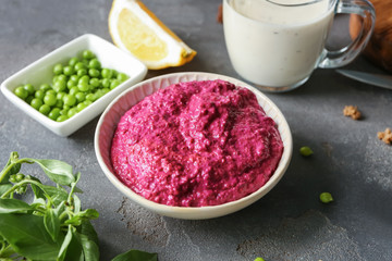 Bowl of fresh beet hummus on table