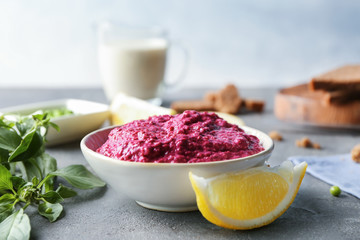 Bowl of fresh beet hummus on table