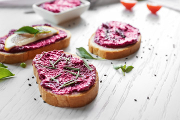 Bread with creamy beet hummus on table