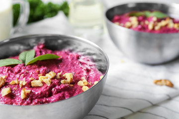 Bowl of fresh beet hummus on table