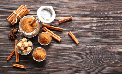 Composition with cinnamon sugar and powder in glassware on wooden background