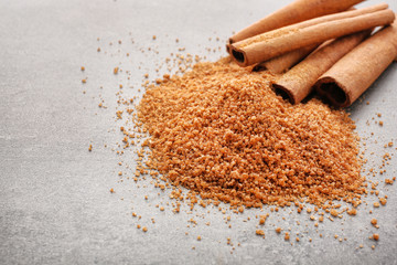 Cinnamon sugar and sticks on grey background