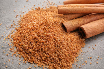 Cinnamon sugar and sticks on grey background