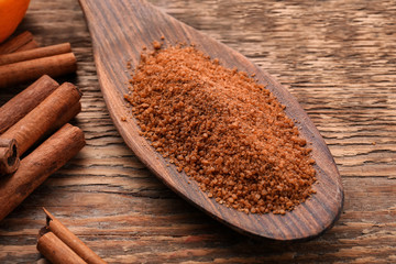 Cinnamon sugar in spoon on wooden background