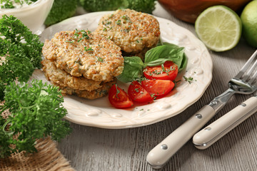Broccoli pancakes served with cherry tomatoes and basil leaves on white plate