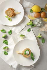 Composition with broccoli pancakes, lemon and basil leaves on table