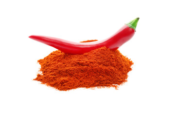 Red pepper pod on pile of chili powder isolated on white