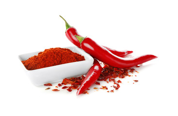 Red chili powder in ceramic bowl with fresh pepper pods on white background - obrazy, fototapety, plakaty