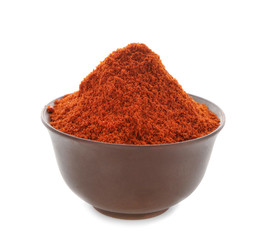 Heap of chili powder in brown pottery bowl isolated on white