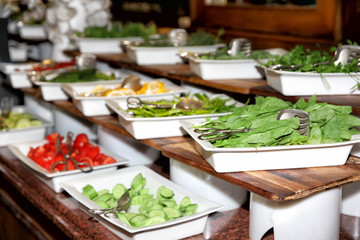 Plates with different kinds of vegetables on table at buffet