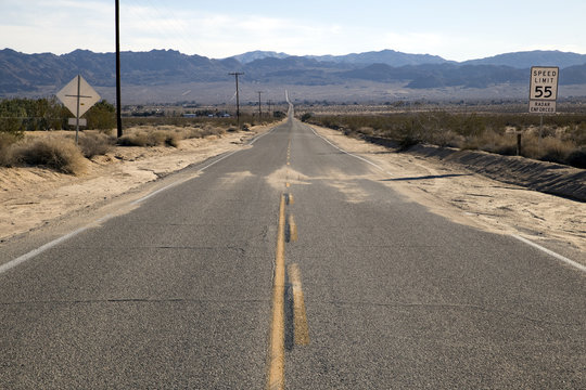 Empty asphalt road through a desert in California, USA	
