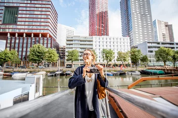 Photo sur Aluminium Rotterdam Jeune femme voyageant dans le port moderne avec des gratte-ciel en arrière-plan dans la ville de Rotterdam