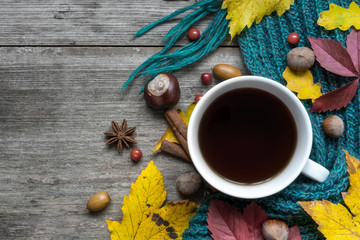 Autumn background with dry leaves, scarf and hot cup of coffee with spices