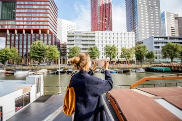 Foto op Plexiglas Young woman photographing modern skyscrapers standing on the harbor in Rotterdam city © rh2010
