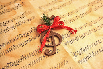 Wooden treble clef on music sheets. Christmas songs concept