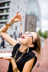 Young woman eating herring with onions traditional dutch snack near the Rotterdam market