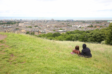 Naklejka premium Couple enjoying the view overlooking beautiful Edinburg, Scotland.