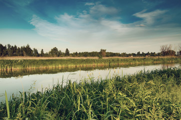 Rural summer sunset landscape with river and dramatic colorful sky