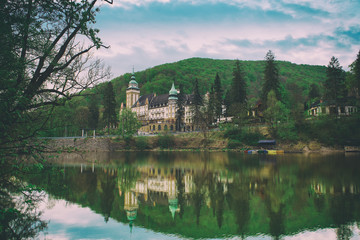 Fototapeta na wymiar Northern front of Lillafured palace in Miskolc, Hungary. Lake Hamori in foreground with reflections. Travel outdoor landmark background