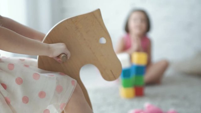 Close-up leg of child riding toy horse while playing at home.