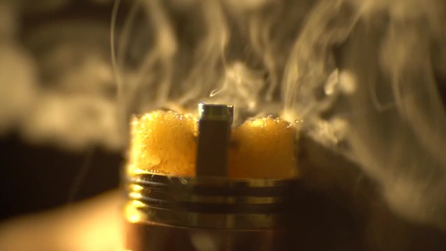 A cloud of vapor flies out of the disassembled evaporator of an electronic cigarette, slow motion