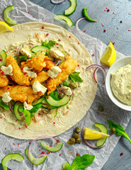 Fresh Fish Tortilla with cucumber, red onion, Capers, lemon, salad leaves and tartare sauce. Healthy Food
