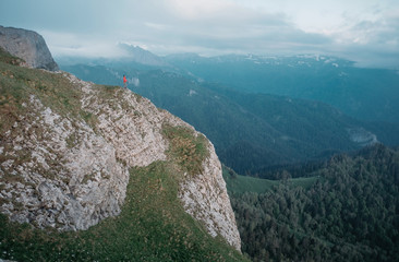 Minimal person standing on massive mountain