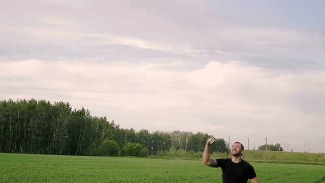 Man lifts a kite into the air and runs slow motion