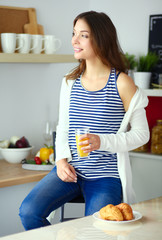 Young woman sitting near desk in the kitchen