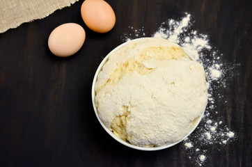the dough in the Cup of flour on the black
