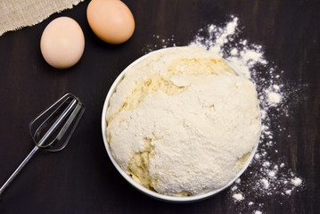 the dough in the Cup of flour on the black