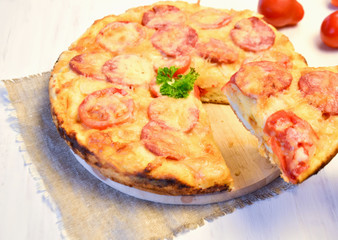 homemade pizza with tomatoes, salami and cheese