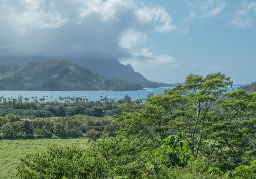 Hanalei bay on a cloudy day, with mountains and lush green landscape, on Kauai