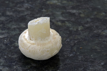 Champignon mushrooms on black granite